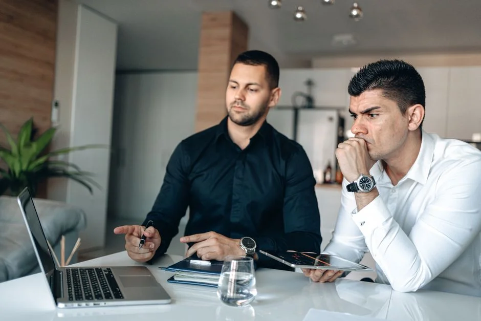 Zwei Personen besprechen gemeinsam am Laptop die Inhalte einer Unternehmenswebsite