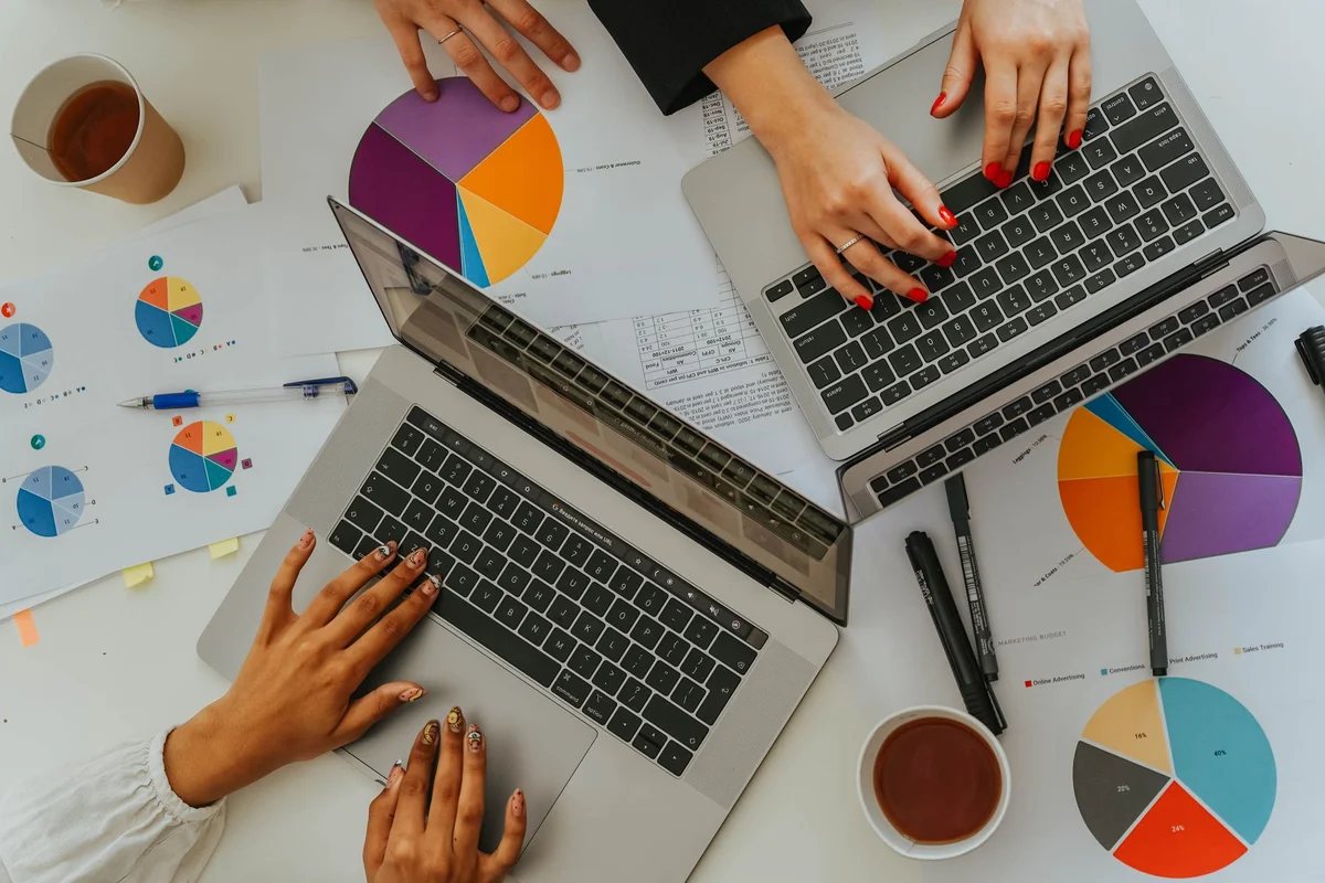 Team wertet Diagramme und Kennzahlen auf Laptops und Papierauswertungen aus