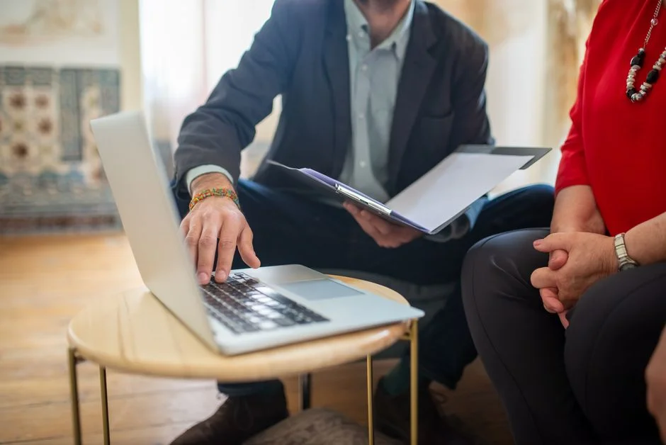 Webdesigner am Laptop zeigt Website-Entwurf für einen kleinen Dienstleistungsbetrieb