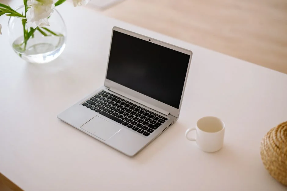 Aufgeräumter Schreibtisch mit Laptop im hellen Büro